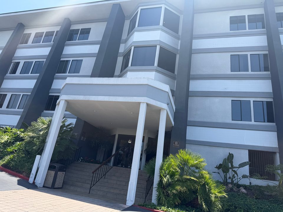 Front entrance of the office building at 2525 Camino del Rio South, with steps under a covered entry